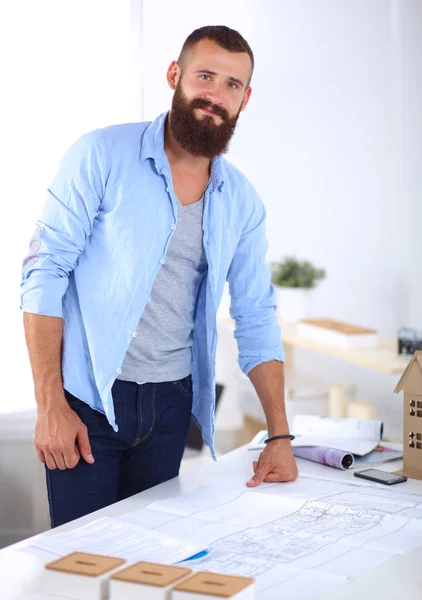 Retrato de diseñador masculino en sombrero con planos en el escritorio —  Fotos de Stock