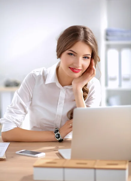 Attraktive Geschäftsfrau sitzt auf Schreibtisch im Büro — Stockfoto