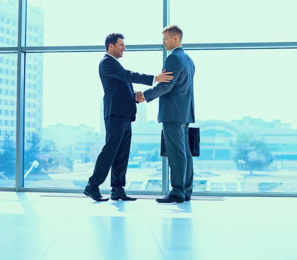 Imagen completa de dos exitosos hombres de negocios estrechándose la mano entre sí —  Fotos de Stock