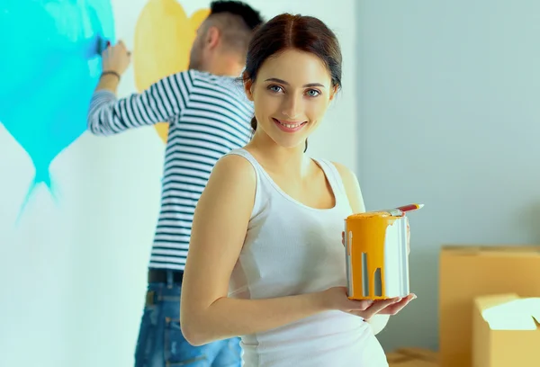 Portrait of happy smiling young couple painting interior wall of new house — Stock Photo, Image