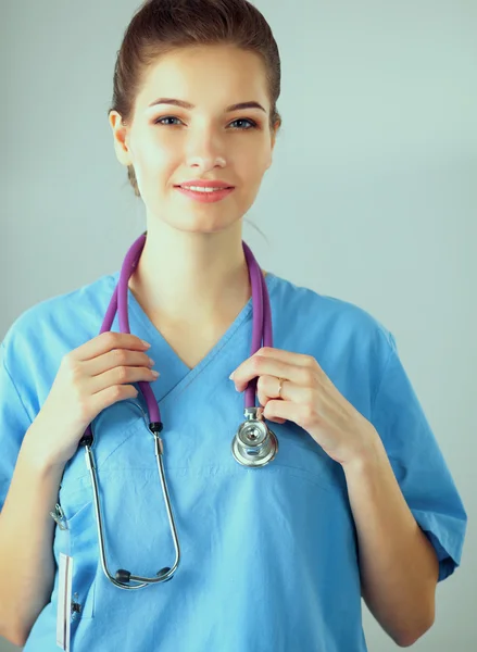 Médecin souriante avec un dossier en uniforme debout à l'hôpital — Photo