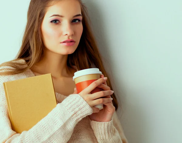 Portrait a young woman with cup of tea or coffee, holding book — Stock Photo, Image
