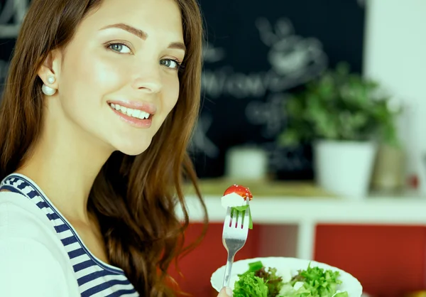 Salata yemek ve karışık salata tutan genç kadın