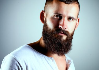 Ayakta, gri arka plan üzerinde izole yakışıklı adam portresi