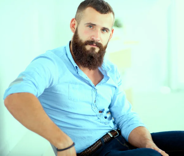 Young businessman sitting on chair in office — Stock Photo, Image