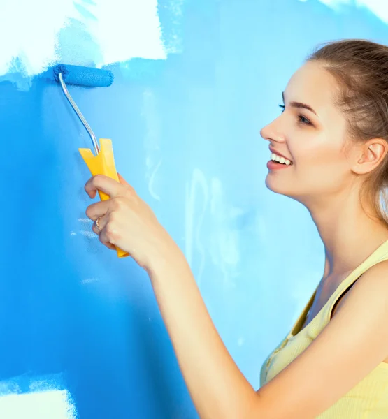 Feliz hermosa joven mujer haciendo pintura de pared — Foto de Stock