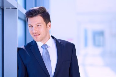 Ofisteki pencerenin yanında duran işadamının portresi