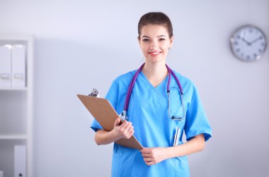 Kadın doktor hastanede dosyayla bekliyor.