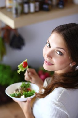 Salata yemek ve karışık salata tutan genç kadın