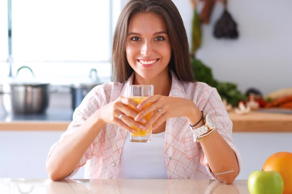 Jovem mulher sentada uma mesa na cozinha — Fotografia de Stock