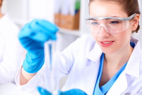 Woman researcher is surrounded by medical vials and flasks, isolated on white background