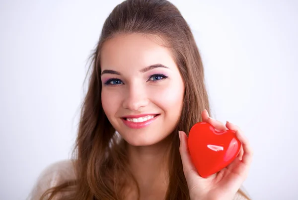 Krásná žena drží červené srdce. — Stock fotografie