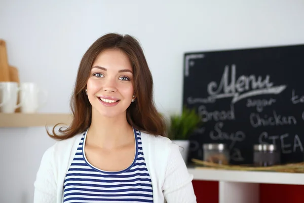 Junge Frau steht neben Schreibtisch in der Küche — Stockfoto