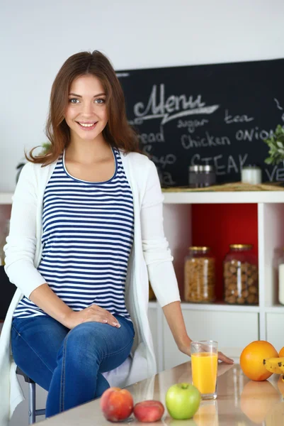 Young woman sitting near desk in the kitchen — Stock Photo, Image