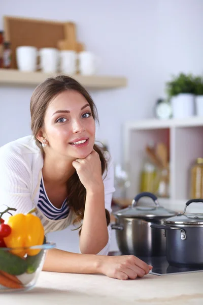 Молодая женщина, стоящая возле стола на кухне — стоковое фото