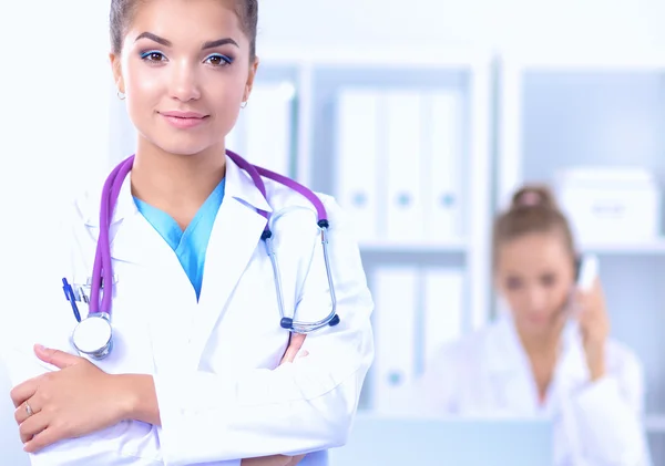 Portrait of young woman doctor with white coat standing in hospital — Stock Photo, Image