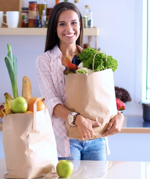Jeune femme tenant sac d'épicerie avec des légumes — Photo