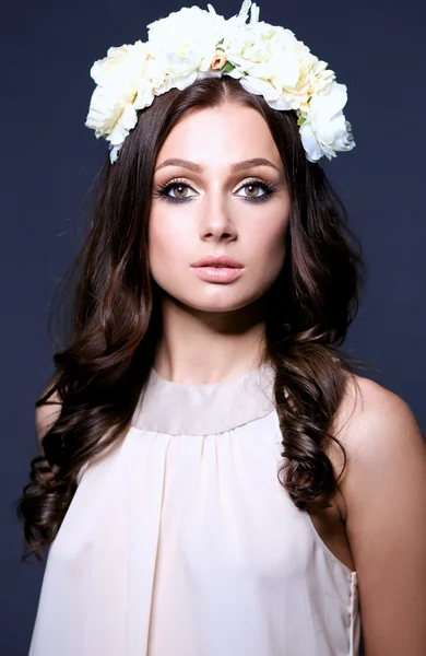 Retrato de una hermosa mujer con flores en el pelo. Moda — Foto de Stock