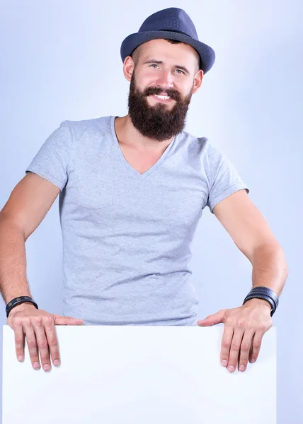 Retrato de jovem de chapéu em pé perto de branco, isolado sobre fundo branco — Fotografia de Stock