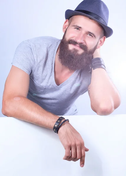 Retrato de jovem de chapéu em pé perto de branco, isolado sobre fundo branco — Fotografia de Stock