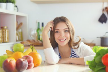 Genç bayan mutfakta masanın yanında oturuyor.