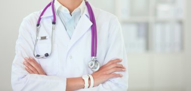 Hastanede üniformalı, gülümseyen bir kadın doktor.