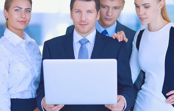 Portrait of young businessman in office with colleagues in the background — Stock Photo, Image