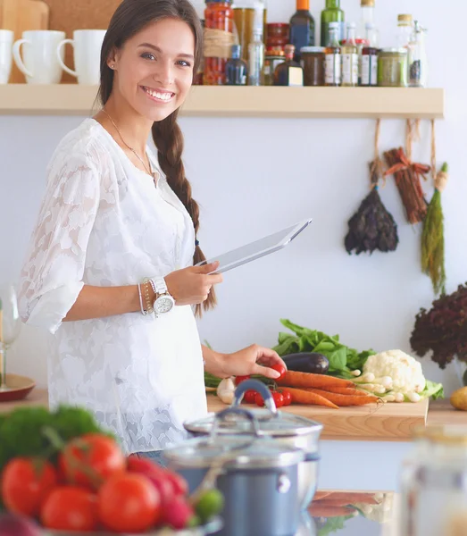 Mujer joven usando una tableta para cocinar en su cocina . —  Fotos de Stock