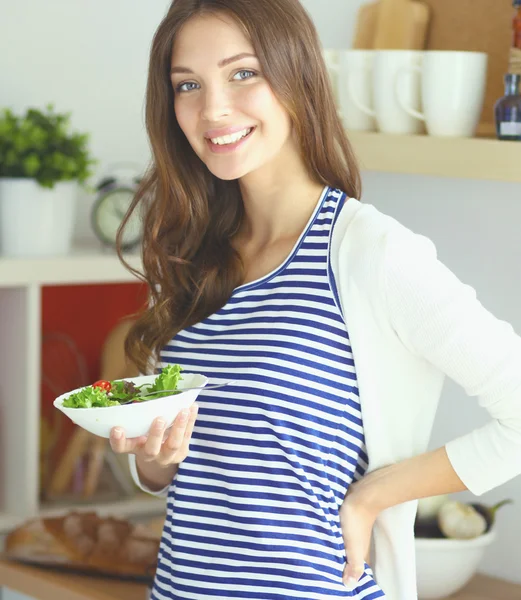 Junge Frau isst Salat und hält einen gemischten Salat in der Hand — Stockfoto