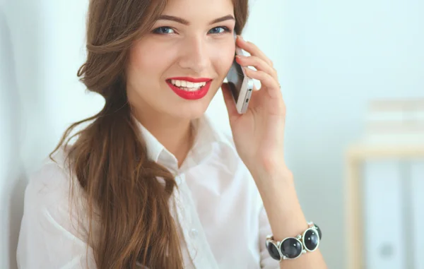 Una mujer de negocios sonriente hablando por teléfono en la oficina —  Fotos de Stock