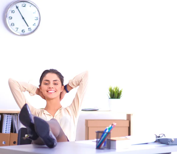 Zakelijke vrouw ontspannen met handen achter haar hoofd en zitten op een bureaustoel — Stockfoto