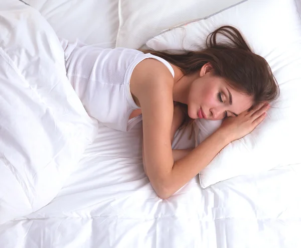 Красивая девушка спит в спальне, лежа на кровати — стоковое фото