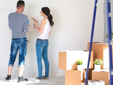 Mutlu gülümseyen genç çift boya iç cephe yeni evin portresi