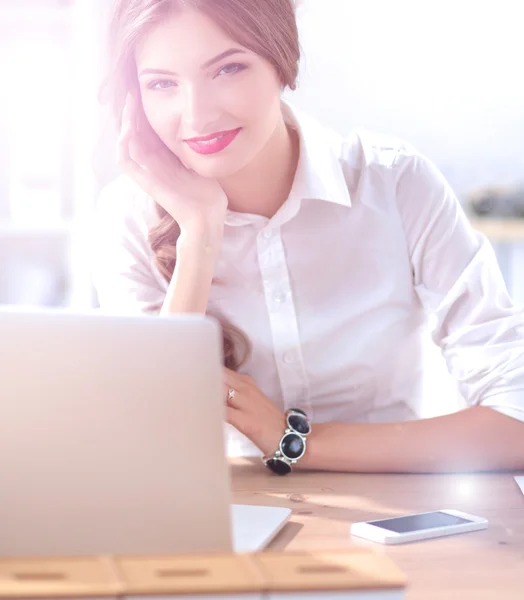 Attraktive Geschäftsfrau sitzt auf Schreibtisch im Büro — Stockfoto