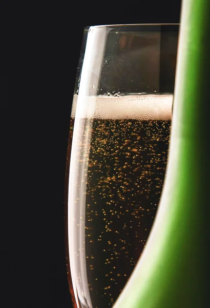 Een glas sprankelende champagne op zwarte achtergrond — Stockfoto