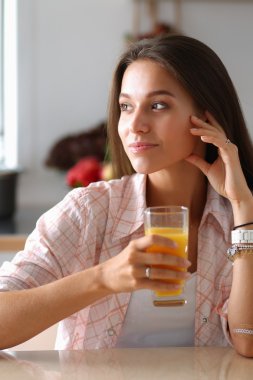 Mutfakta masada oturan genç bir kadın.