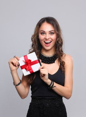 genç kadın mutlu gülümseme hediye kutusu gri arka plan üzerinde izole elinde tut