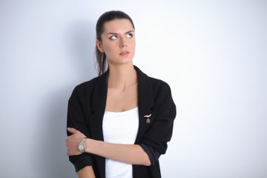 Genç bir kadın ayakta, gri arka plan üzerinde izole