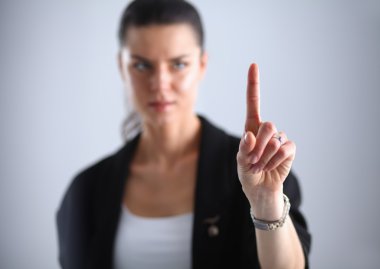 Kadın parmaklarıyla hayali bir ekrana dokunuyor.