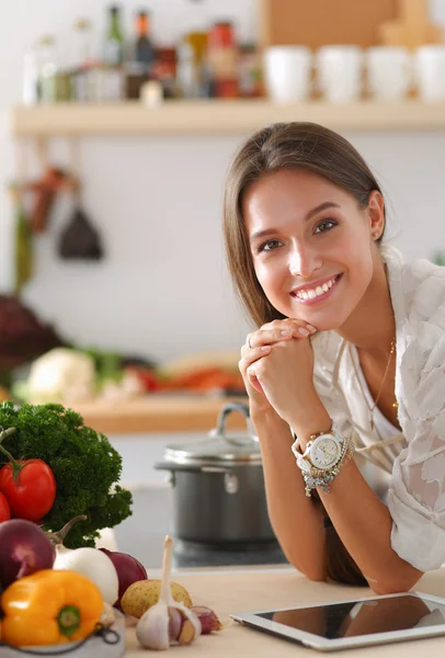 Mujer joven usando una tableta para cocinar en su cocina . —  Fotos de Stock