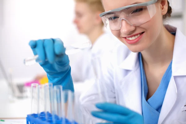 Vrouwelijke onderzoeker is omringd door medische flacons en flacons, geïsoleerd op witte achtergrond — Stockfoto