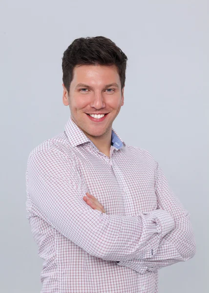 Portrait of confident young man standing arms crossed — Stock Photo, Image