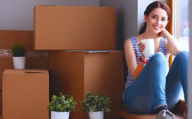 Karton kutuları olan yeni bir evde bir kadın.