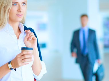 Yound kadın ayakta ofisindeki kahve içmek