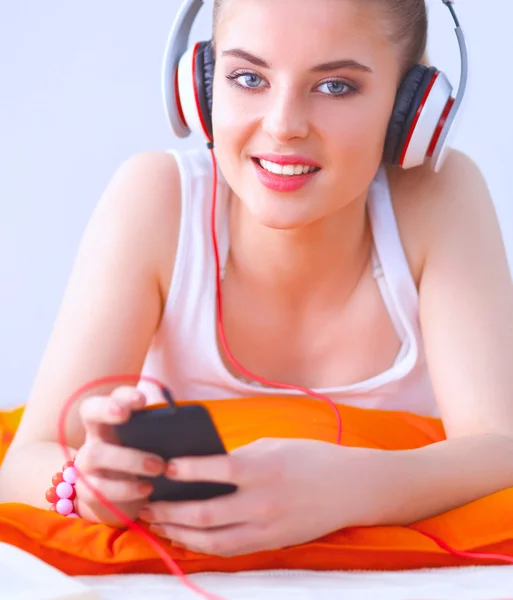Jonge vrouw liggend op verdieping en luisteren naar muziek — Stockfoto