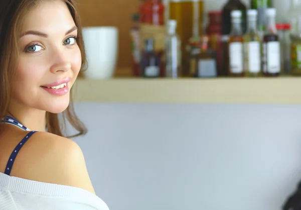 Jonge vrouw met behulp van een tablet computer om te koken in haar keuken . — Stockfoto