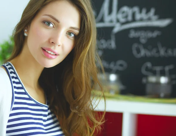 Giovane donna che utilizza un tablet per cucinare nella sua cucina . — Foto Stock