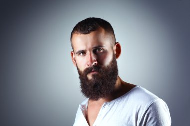 Ayakta, gri arka plan üzerinde izole yakışıklı adam portresi