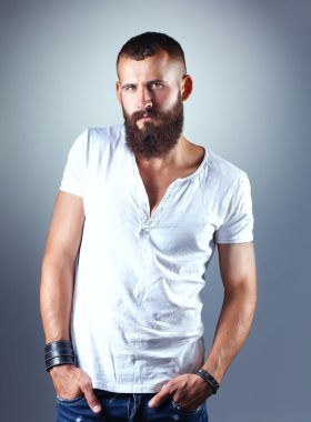 Ayakta, gri arka plan üzerinde izole yakışıklı adam portresi