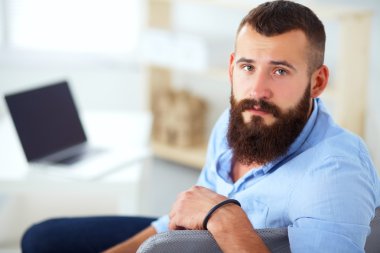 Genç işadamı koltukta oturuyor.